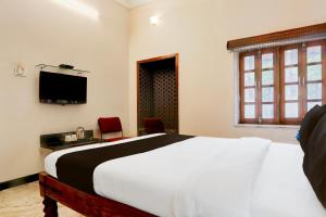 a bedroom with a large bed and a television at Collection O Rai Ka Bagh Near Railway Station Formerly Pioneer Plaza in Jodhpur