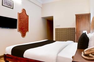 a bedroom with a large white bed and a desk at Collection O Rai Ka Bagh Near Railway Station Formerly Pioneer Plaza in Jodhpur