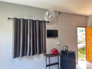 a black curtain in a room with a table and a fan at บ้านวังปลาปาย in Pai