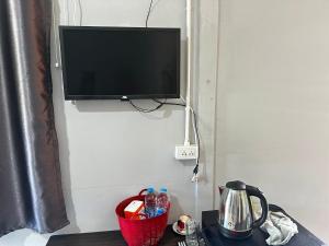a flat screen tv hanging on a wall with a table at บ้านวังปลาปาย in Pai