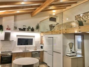 eine Küche mit weißen Geräten und einem weißen Tisch in der Unterkunft Zeca Holidays -Atalaia Fall Mezanine Ideal para trabalhar in Lourinhã