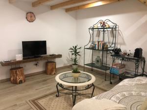 ein Wohnzimmer mit Tisch und Fernseher in der Unterkunft Zeca Holidays -Atalaia Fall Mezanine Ideal para trabalhar in Lourinhã