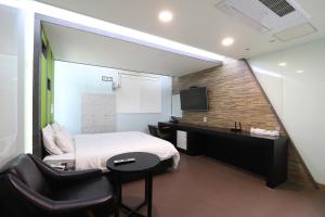 a bedroom with a bed and a desk and a tv at Nampo MGM Hotel in Busan +18 photos