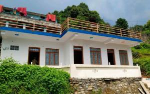 a house with a balcony on top of it at Himadri Homestay Sari Devriyatal in Sari
