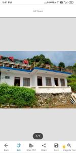 a picture of a white house with at Himadri Homestay Sari Devriyatal in Sari