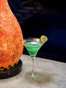 a green drink in a martini glass next to a melon at Brother Hotel & Travel in Cat Ba +20 photos