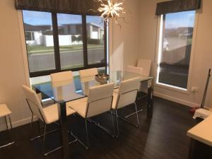 a dining room with a glass table and chairs at Parklands paradise 3bedroom4beds in Napier
