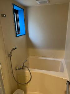 een badkamer met bad, douche en toilet bij Shinehouse2 in Kawaguchi