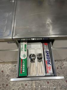 een metalen plank met keukengerei in een lade bij Shinehouse2 in Kawaguchi