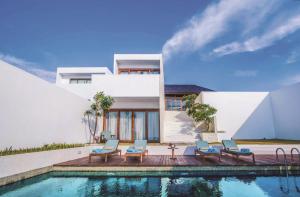a house with a swimming pool in front of a house at Montigo Resorts Nongsa in Nongsa