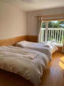 2 letti singoli in una camera da letto con finestra di aomame villa lake toya a Lago Toya