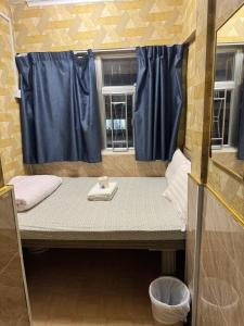 ein kleines Zimmer mit einem Bett und einem Fenster in der Unterkunft Prime Star Guest House in Hongkong