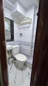 ein Badezimmer mit weißer Toilette und Waschbecken in der Unterkunft Prime Star Guest House in Hongkong + 14 Fotos