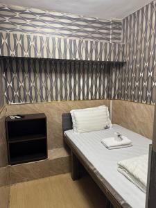 ein kleines Zimmer mit einem Bett und einem Tisch in der Unterkunft Prime Star Guest House in Hongkong