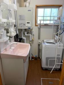 un bagno con lavandino e lavatrice di aomame villa lake toya a Lago Toya Altre 41 foto