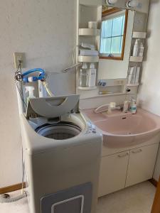 una lavatrice in bagno con lavandino di aomame villa lake toya a Lago Toya