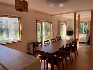 a dining room with a wooden table and chairs at aomame villa lake toya in Lake Toya