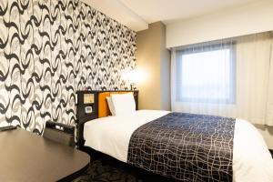 Schlafzimmer mit einem Bett mit einer schwarz-weißen Wand in der Unterkunft APA Hotel Biwako Seta Ekimae in Ōtsu