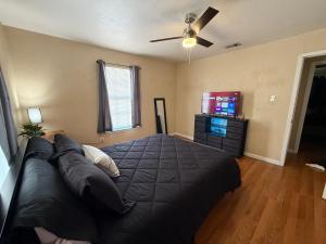 um quarto com uma grande cama preta e uma televisão em Eagle Stay 3 em Eagle Pass