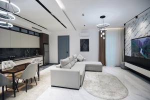 een woonkamer met een witte bank en een tafel bij RIO Hotel in Samarkand
