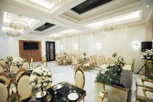 een feestzaal met tafels, stoelen en bloemen bij RIO Hotel in Samarkand