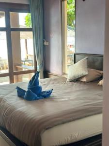 Lanta Bee Garden Bungalow SHA Extra Plus في كو لانتا: وجود حيوان محشو ازرق جالس فوق السرير