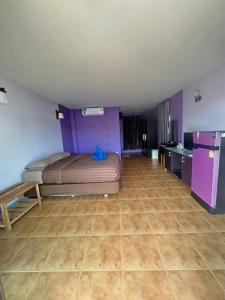 Lanta Bee Garden Bungalow SHA Extra Plus في كو لانتا: غرفة نوم بسرير وجدران ارجوانية