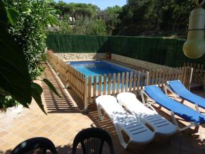 ein Pool mit Liegestühlen und einem Pool,in dem die materielle Verwertbarkeit gewährleistet ist in der Unterkunft Azahara in Lloret de Mar