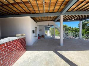 een patio met een bakstenen muur en een houten plafond bij New Land Hostel in Kaôh Rŭng (3)