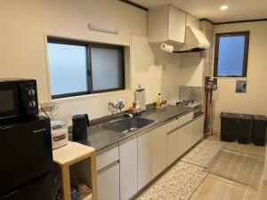 eine Küche mit Spüle und Kühlschrank in der Unterkunft Shinehouse2 in Kawaguchi
