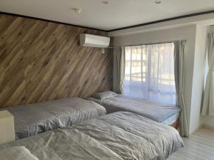 ein Schlafzimmer mit zwei Betten und einem Fenster in der Unterkunft Shinehouse2 in Kawaguchi