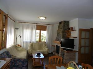 ein Wohnzimmer mit einem Sofa und einem TV in der Unterkunft Azahara in Lloret de Mar