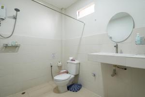 a bathroom with a toilet and a sink and a mirror at Lanta Beachfront Resort in Ko Lanta +50 photos