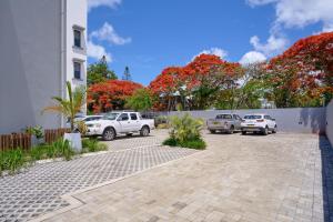 a parking lot with cars parked in front of a building at Residence ORYAM in Trou aux Biches