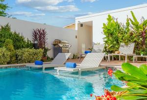 2 Stühle und ein Pool im Hinterhof in der Unterkunft Modern Studio w/ Pool, Gym & Rooftop Palm Beach in Palm-Eagle Beach