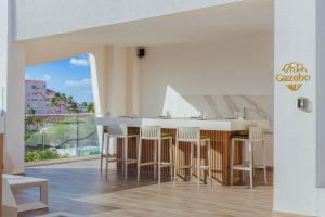 eine Küche mit einer Bar mit Stühlen und einem großen Fenster in der Unterkunft Modern Studio w/ Pool, Gym & Rooftop Palm Beach in Palm-Eagle Beach