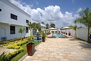 a resort with a swimming pool and palm trees at Newport Hotel in Atimpoko