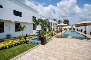 a resort with a swimming pool and a building at Newport Hotel in Atimpoko