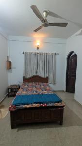 een slaapkamer met een bed met een plafondventilator bij Portal Apartment in Arambol