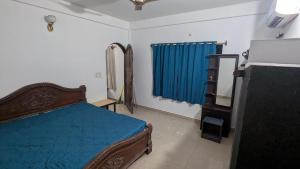 een slaapkamer met een blauw bed en een blauw gordijn bij Portal Apartment in Arambol