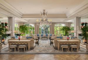 a living room filled with tables and chairs at The Peninsula Beverly Hills in Los Angeles