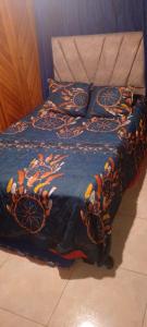 een bed met een blauw dekbed en kussens erop bij casa de hospedaje urcunina in Pasto