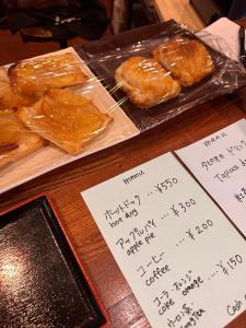 a table with a tray of pastries and handwritten notes at ウッディハウス満月 in Nozawa Onsen +17 photos