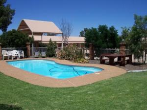 a swimming pool with a picnic table and a picnic table at Lucky Strike Motel in Tomingley