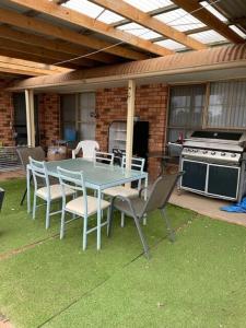a table and chairs on a patio with a stove at Lucky Strike Motel in Tomingley