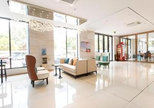 a living room with a couch and chairs at City Comfort Inn Liuzhou Chengzhong Wanda Haiguan in Liuzhou