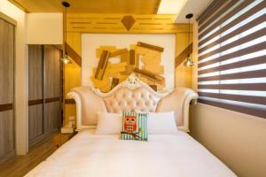 a bedroom with a white bed with a large headboard at Miller Homestay in Wujie