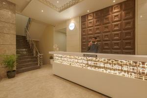 Ein Mann, der auf einem Handy in der Lobby spricht. in der Unterkunft Pax Hotel Welcome Inn Opp Railway Station in Amritsar