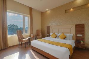 ein Hotelzimmer mit einem großen Bett und einem Fenster in der Unterkunft Pax Hotel Welcome Inn Opp Railway Station in Amritsar + 42 Fotos