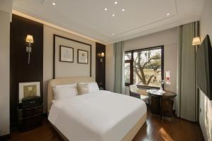 een slaapkamer met een groot wit bed en een raam bij 青岛阿特拉酒店 in Qingdao